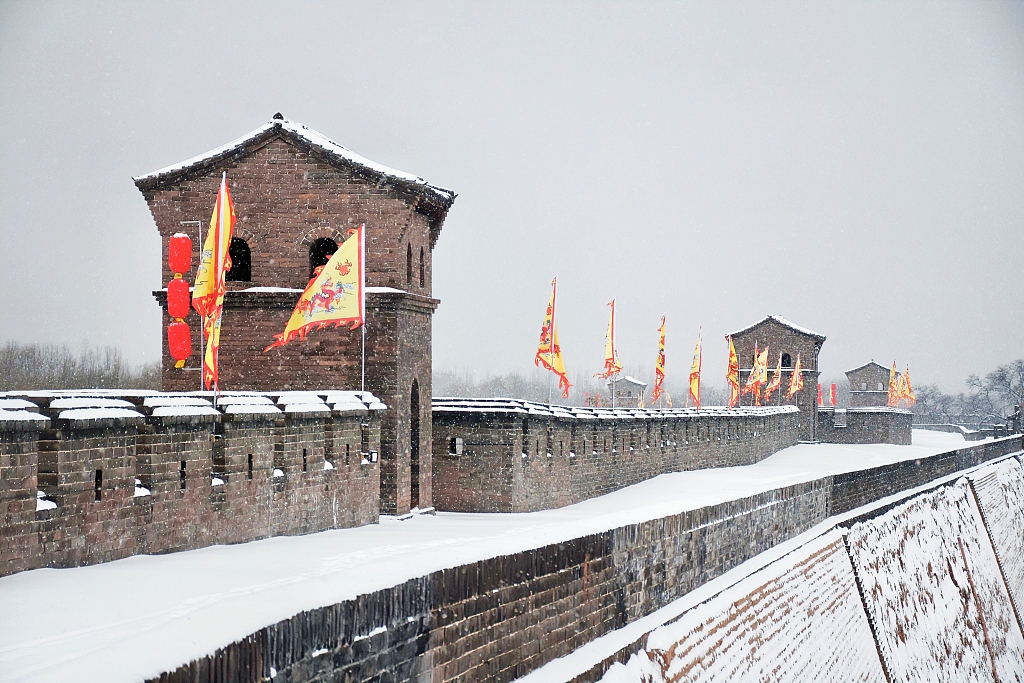 The city walls of Pingyao have a solemn appearance in snow. /CFP