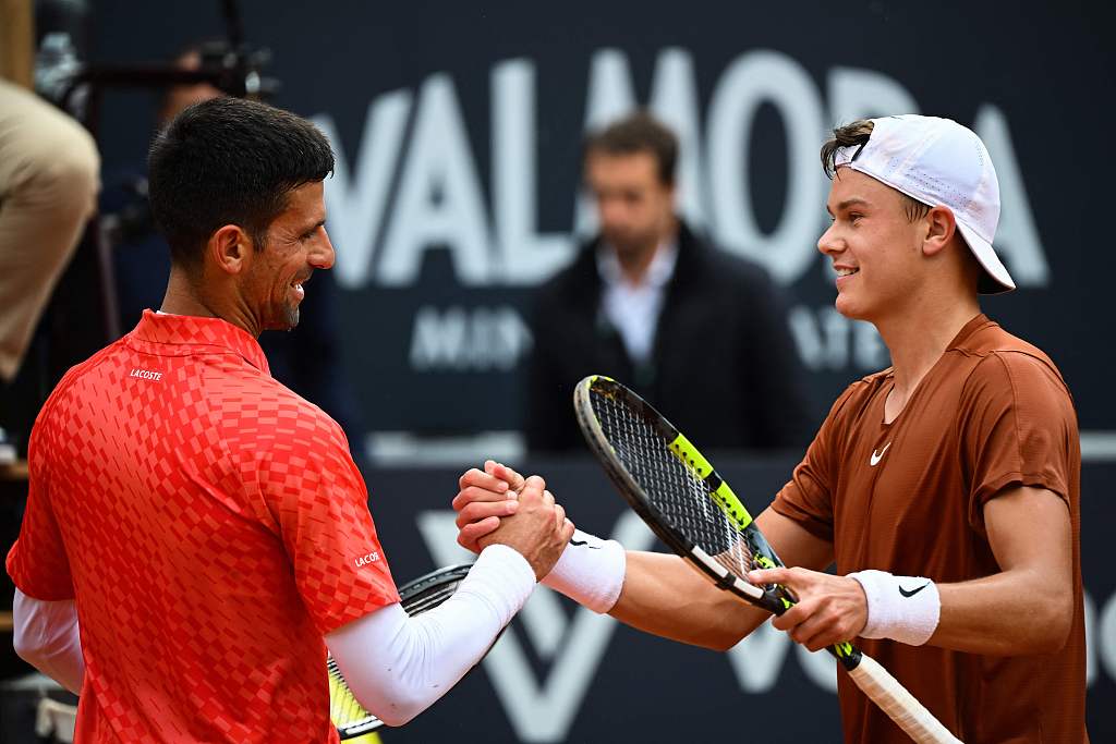 Denmark's Holger Rune (R) and Serbia's Novak Djokovic shake hands after Rune won their men's singles quarter-final at the Italian Open in Rome, May 17, 2023. /CFP
