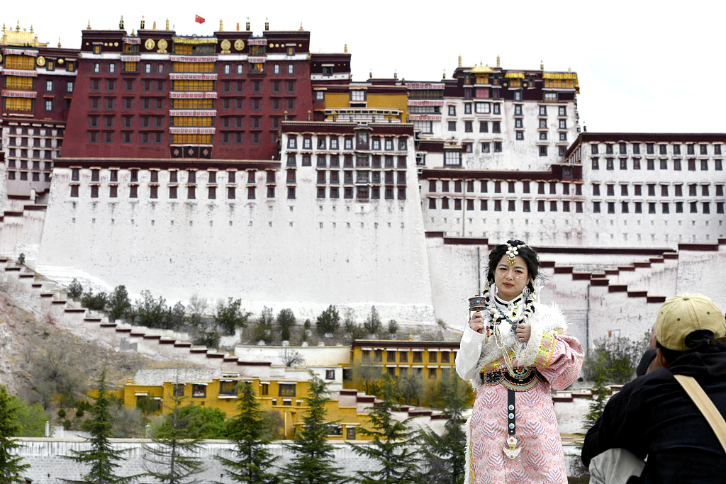 A visitor wears Tibetan clothing for a photo shoot in Lhasa, Xizang, on May 19, 2023. /CFP