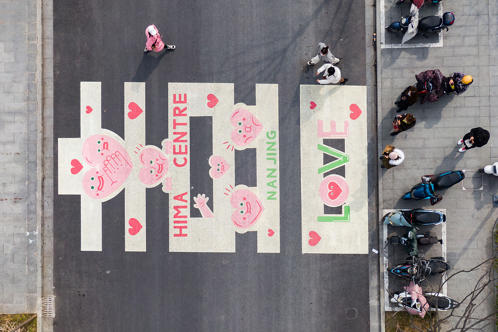 A zebra crossing in the city of Nanjing, Jiangsu is decorated with romantic pink and green patterns and letters, February 21, 2022. /CFP
