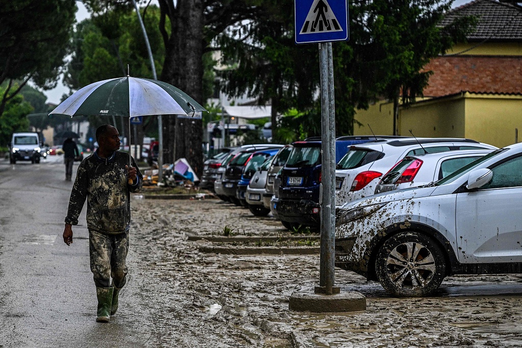 A resident covered in mud walks across a muddy street in Faenza, after floodwaters hit the Emilia Romagna region, Italy, May 19, 2023. /CFP