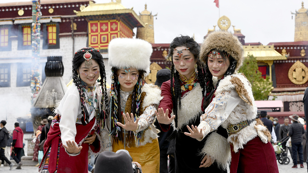 People pose for a photo in Jokhang Temple Square in Lhasa City, southwest China's Xizang Autonomous Region, May 19, 2023. /CFP