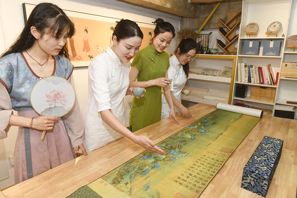 A group of young people enjoy tea and admire fan paintings in Fuyang, Anhui Province, on May 18, 2023, to embrace the International Tea Day. /CFP
