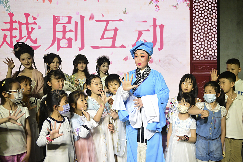 A Yue Opera artist interacts with children at a museum night event in Suzhou City, Jiangsu Province. /CFP