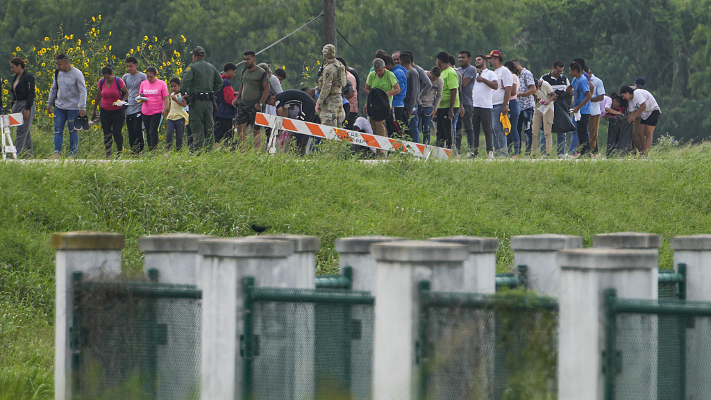 Migrants along a road near the Rio Grande after crossing the Texas-Mexico border in Brownsville, Texas, May 11, 2023. /CFP