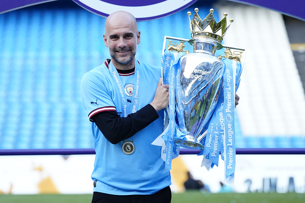 Manchester City manager Pep Guardiola poses with the trophy as he celebrates the Premier League title at Etihad Stadium in Manchester, England, May 21, 2023. /CFP 