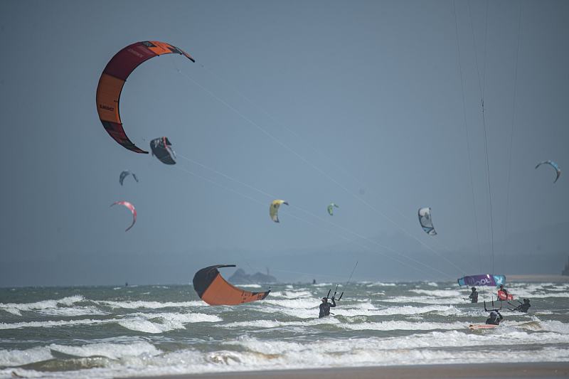 Kiteboarders participate in a competition in Qionghai City, Hainan Province, on May 22, 2023. /CFP