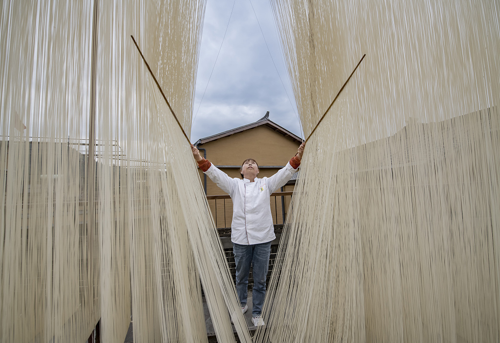 A man dries noodles in Zhongjiang County in southwest China’s Sichuan Province. The Zhongjiang hanging noodles are purely handmade and are well known in China for their thinness and tender texture. /CFP