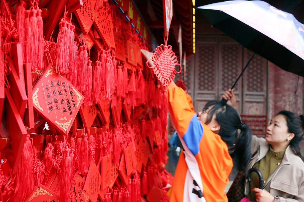 Students and parents are seen outside the Temple of Confucius hanging their wishes and hopes for good test scores in Qufu, Shandong Province, May 21, 2023. /CFP