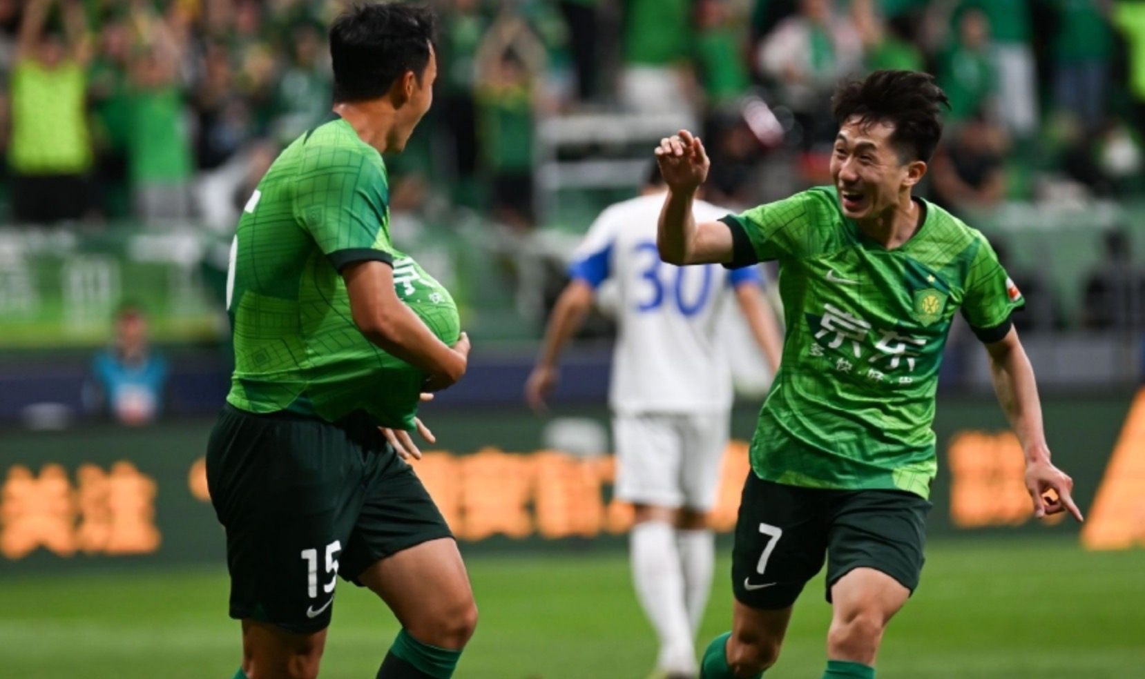 Beijing Guoan's Kang Sang-woo (R) reacts after notching an assist for Gao Tianyi (L) during their Chinese Super League clash with Cangzhou Mighty Lions at the new Workers' Stadium in Beijing, China, May 23, 2023. /Beijing Guoan