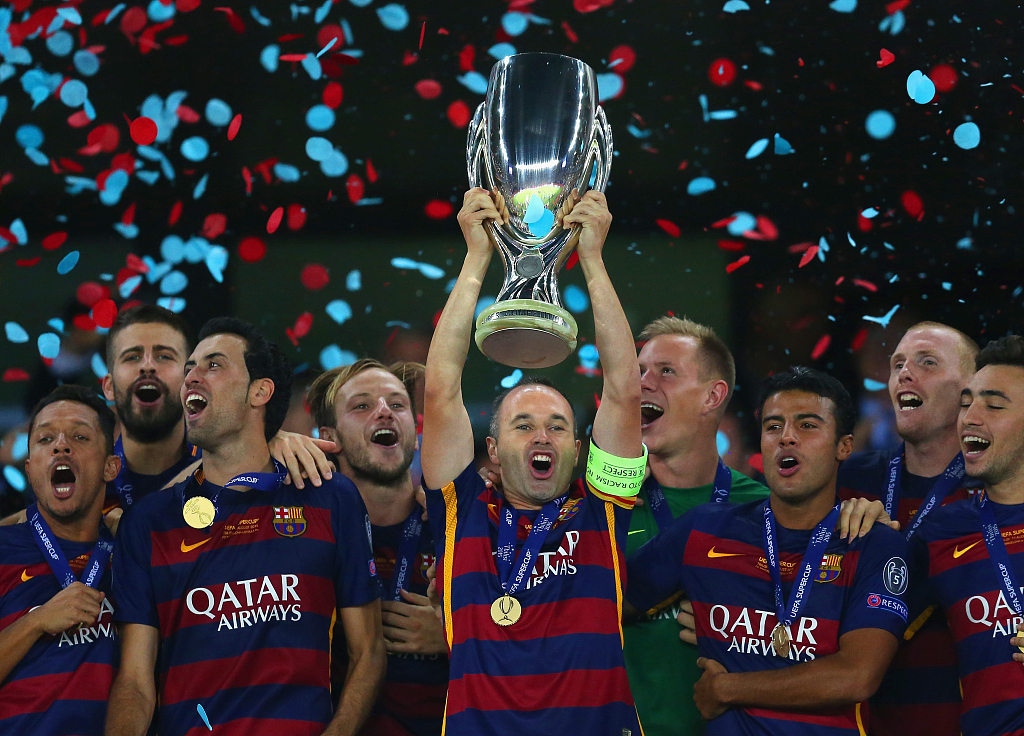 Andres Iniesta (C) of Barcelona lifts the trophy after winning the Super Cup between Barcelona and Sevilla FC at Dinamo Arena in Tbilisi, Georgia, August 11, 2015. /CFP 