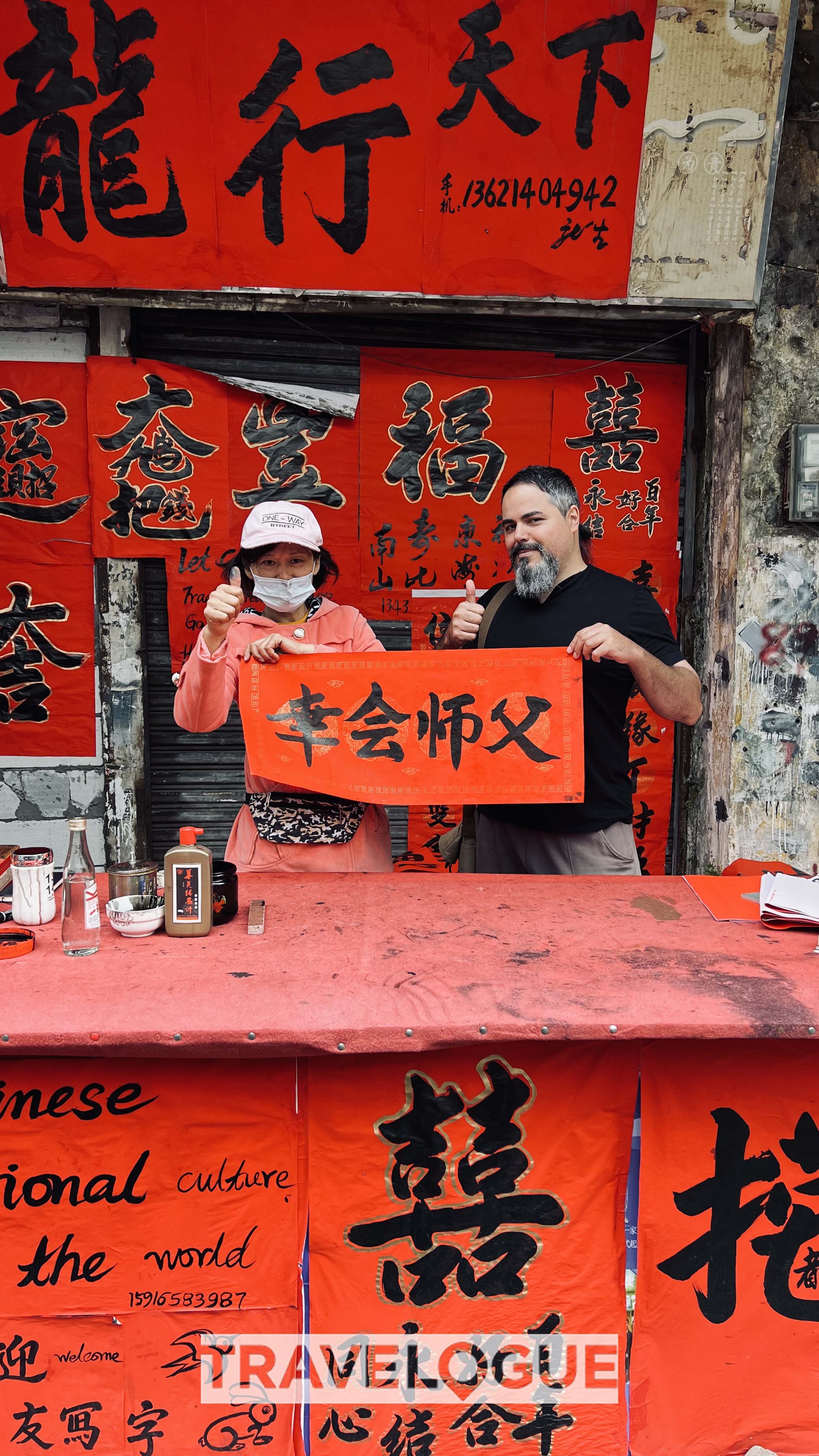 A tourist visits Kuaizi Road to buy handwritten couplets. /CGTN