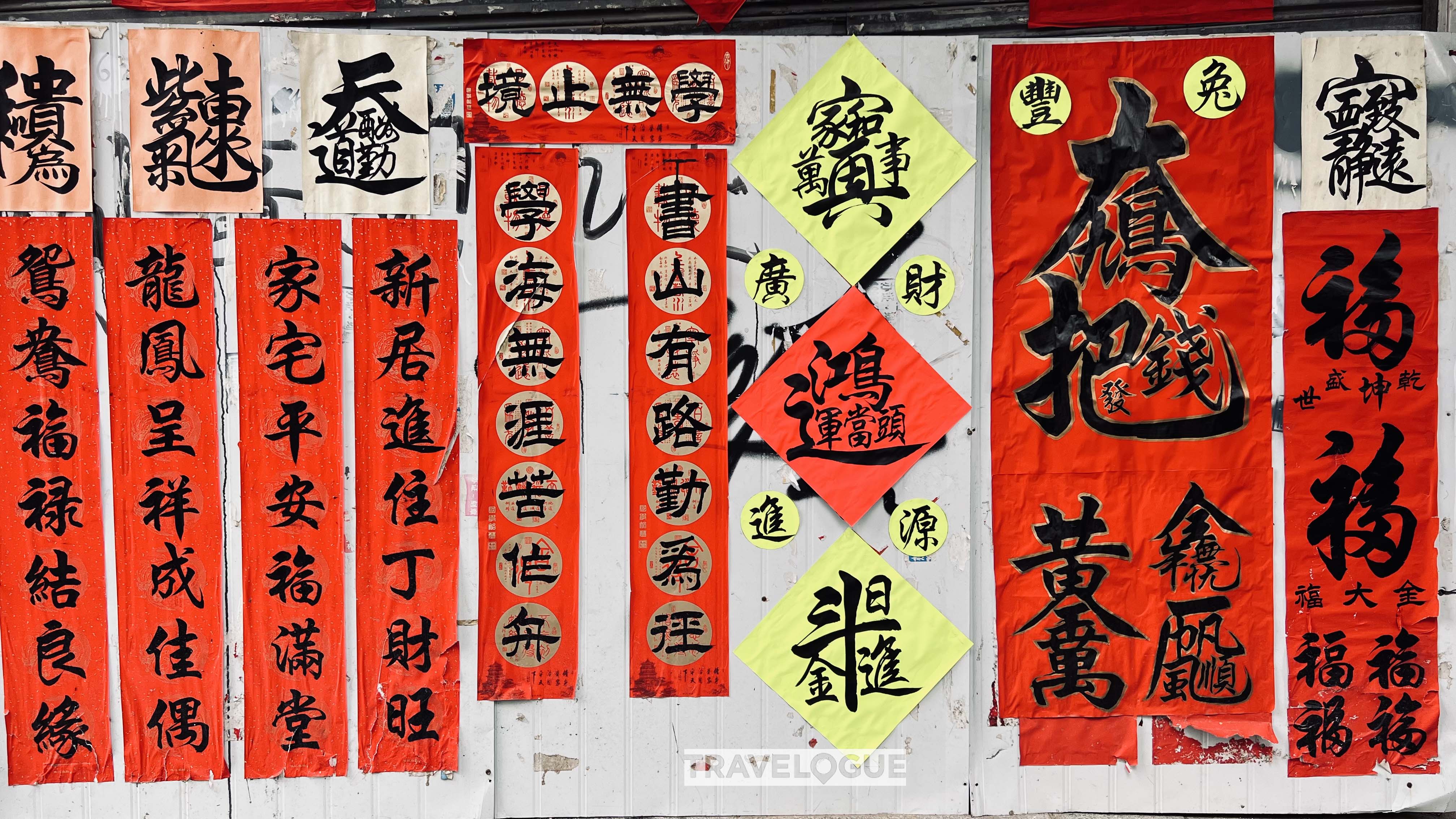 Various handwritten couplets are pasted on a wall of Kuaizi Road. /CGTN
