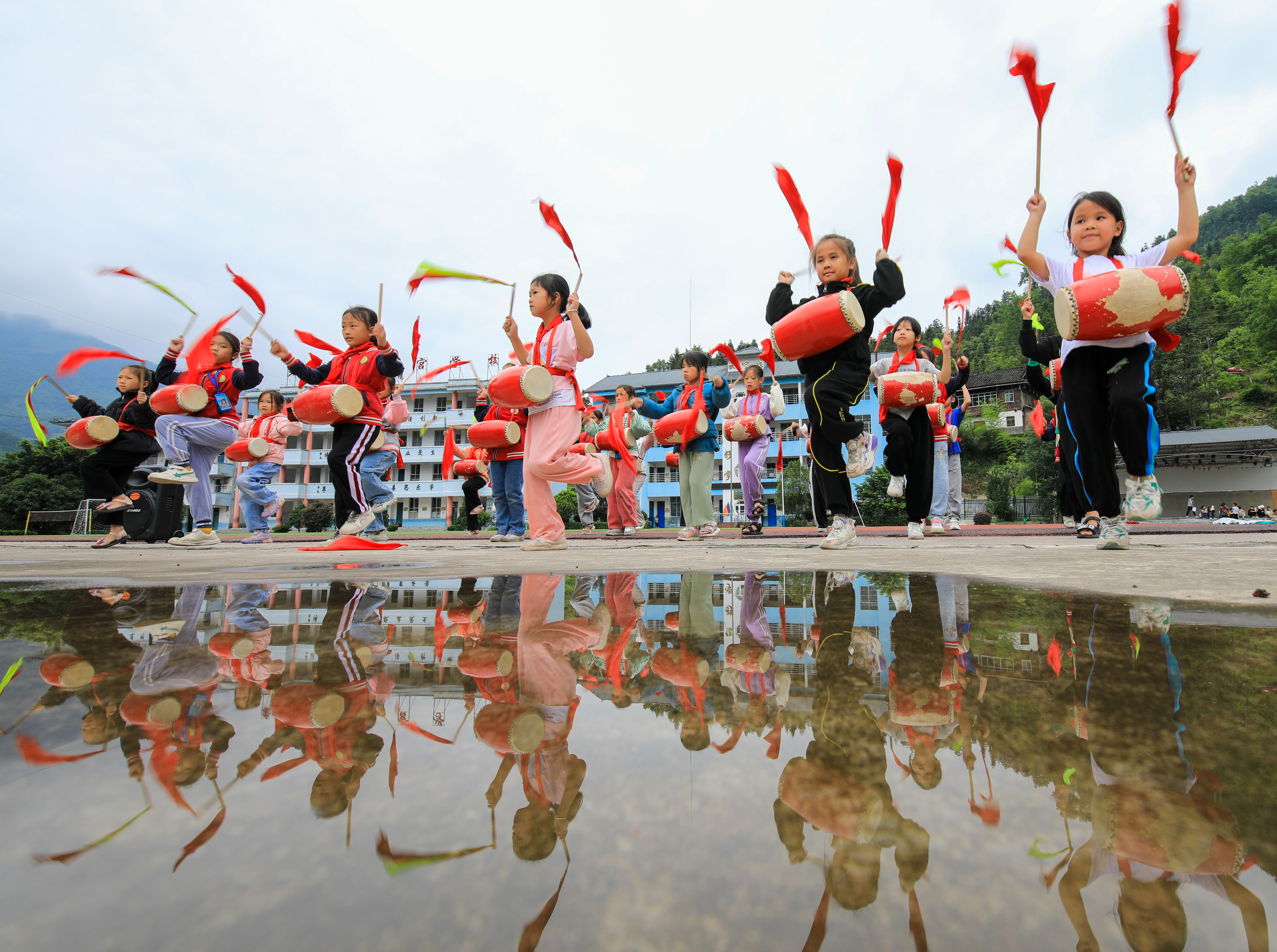 Pupils from a primary school in Gangbian Township of southwest China's Guizhou perform waist-drum dance on May 24, 2023. /CNSPHOTO