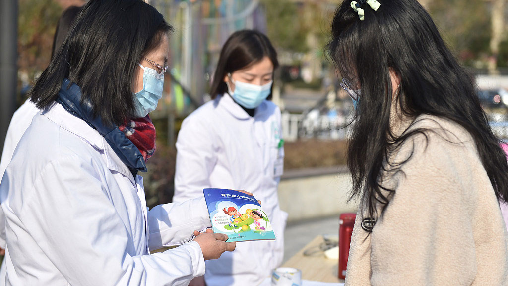 Health professionals distribute reading materials about birth defects, Hefei City, east China's Anhui Province, February 15, 2023. /CFP