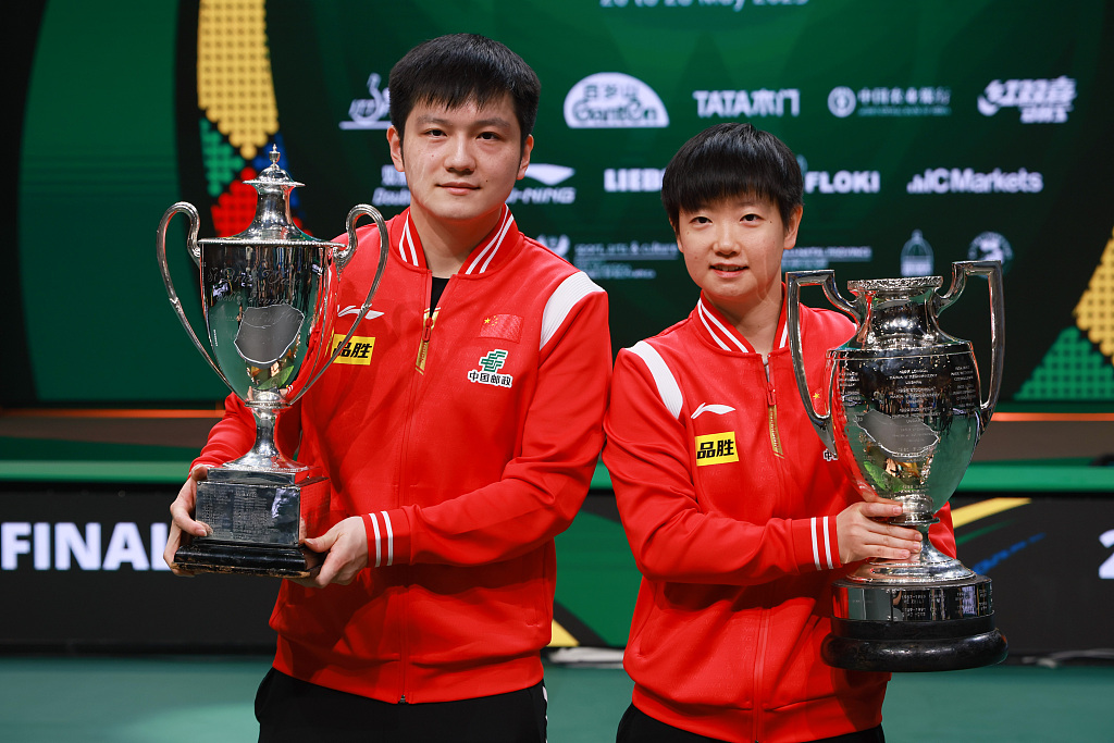 China's Fan Zhendong (L) and Sun Yingsha hold their trophies after winning the ITTF World Table Tennis Championships Finals in Durban, South Africa, May 28, 2023. /CFP