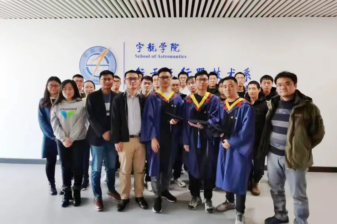 Gui Haichao (second from the left in the front row) taking a group photo with master's graduates from the laboratory. /School of Astronautics at Beihang University 