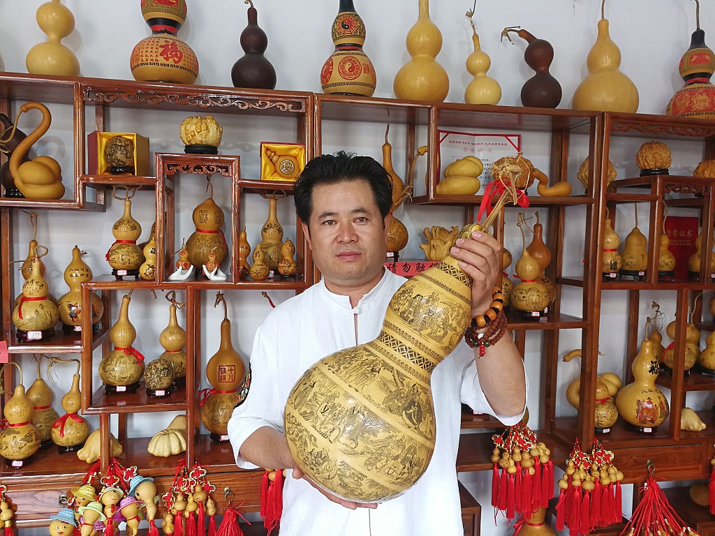 Gourd carving master Bai Zhengbing shows his work in Linxia, northwest China's Gansu. /CFP