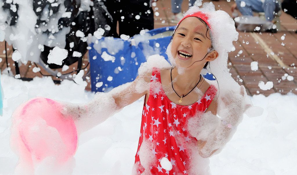 A child happily plays in a sea of foam in Kunming, southwest China's Yunnan. /CFP