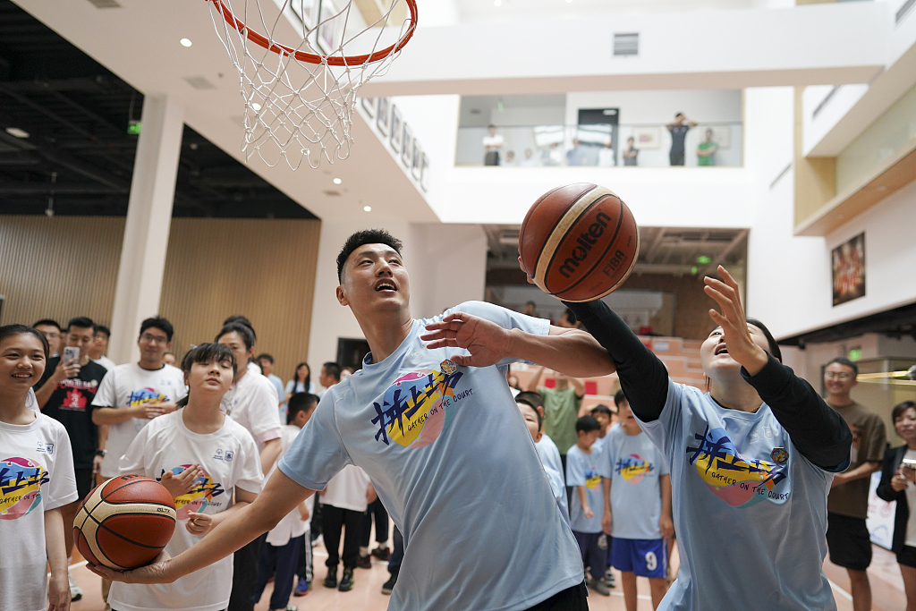 A Special Olympics athlete (R) shoots a layup in the 