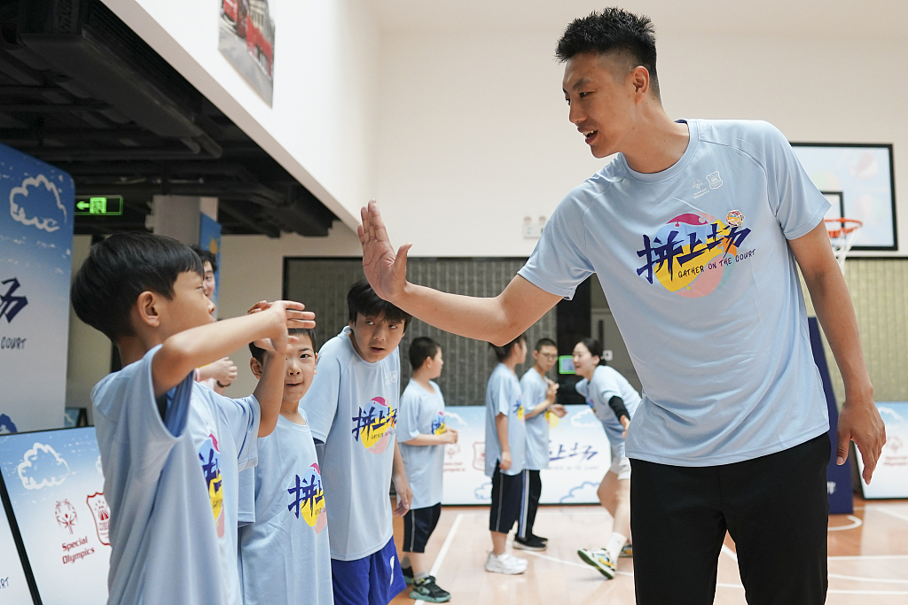 CBA player Zhai Xiaochuan (R) high-fives a Special Olympics athlete in the 