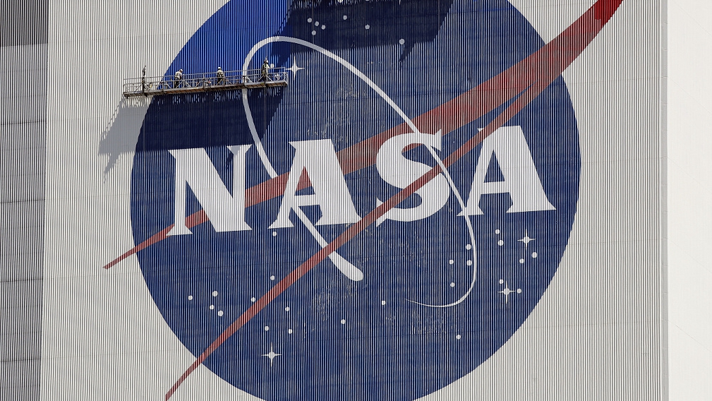 Workers on scaffolding repaint the NASA logo near the top of the Vehicle Assembly Building at the Kennedy Space Center in Cape Canaveral, Florida, U.S., May 20, 2020. /CFP