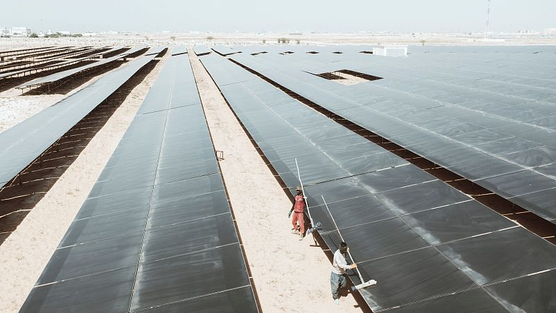 This aerial view shows workers cleaning solar panels at the 15MW Sheikh Zayed Solar Power Plant in Nouakchott, Mauritania, March 21, 2023. /CFP 