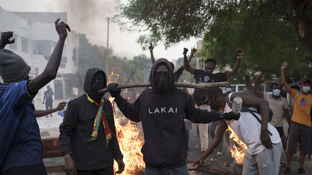 Demonstrators stand next to a barricade set on fire during a protest in support of the main opposition leader Ousmane Sonko in Dakar, Senegal, Monday, May 29, 2023. /CFP