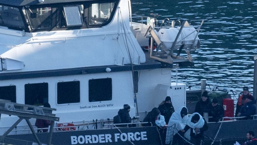 Migrants are escorted off the UK Border Force cutter 