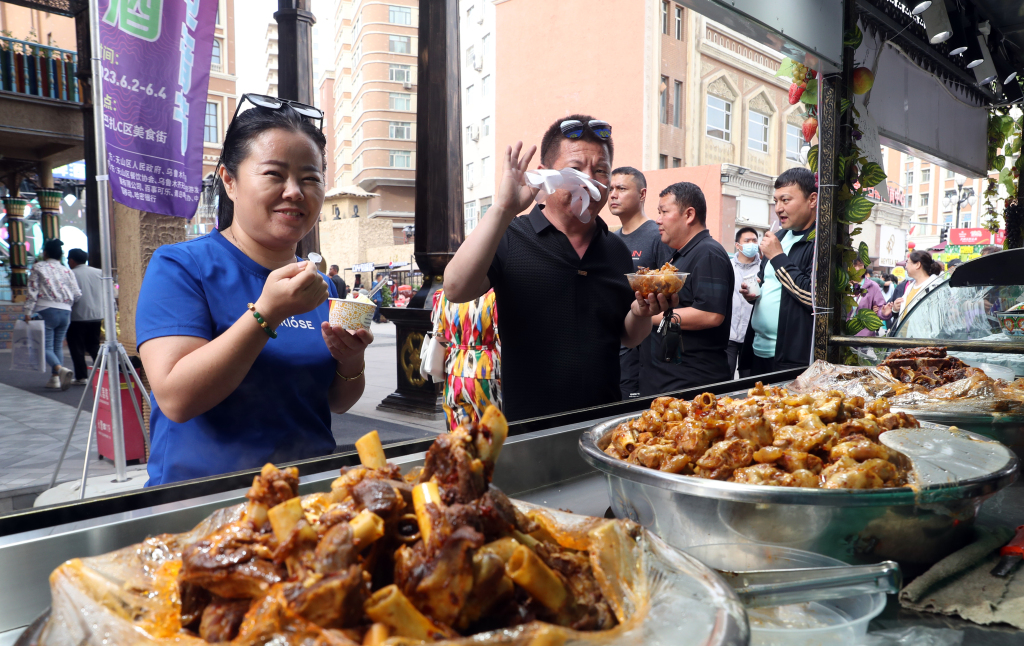 Visitors enjoy delicacies at the Xinjiang International Grand Bazaar in Urumqi, northwest China's Xinjiang Uygur Autonomous Region on June 1, 2023. /CFP