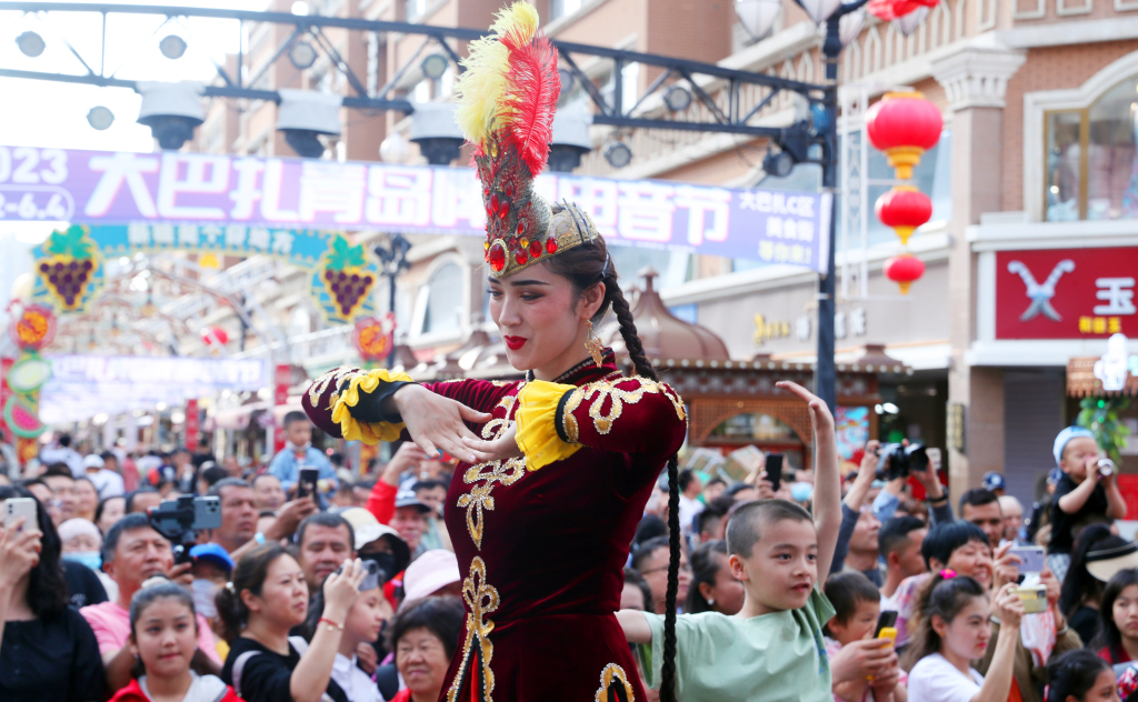 Visitors watch a cultural performance staged at the Xinjiang International Grand Bazaar in Urumqi, northwest China's Xinjiang Uygur Autonomous Region on June 1, 2023. /CFP