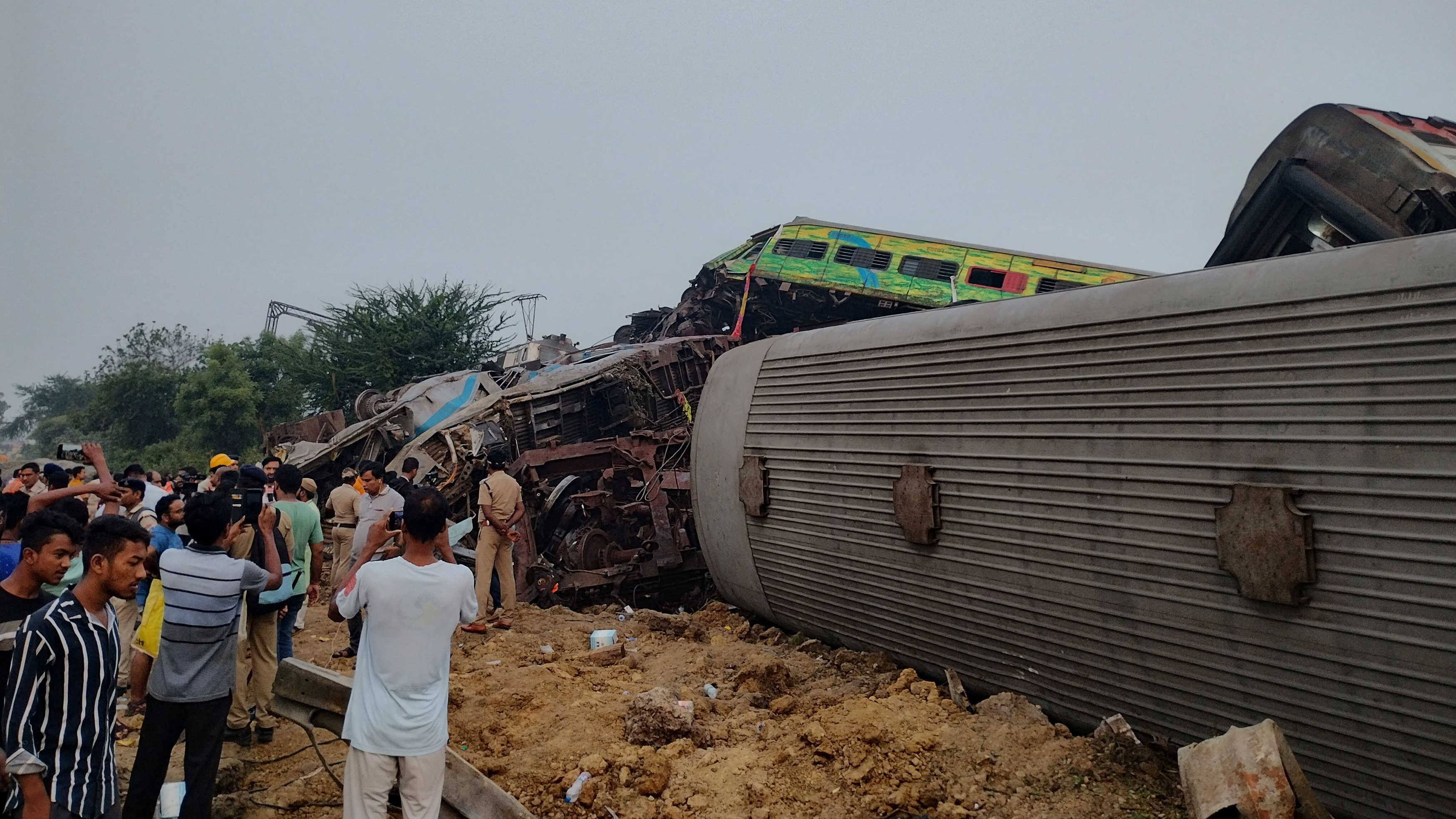 Onlookers and rescue workers stand next to damaged coaches, after trains collided in Balasore, India June 3, 2023, in this picture obtained from social media. /Reuters