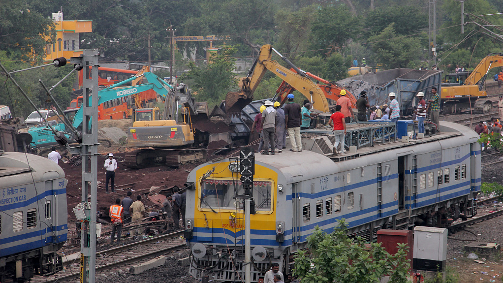 Railway workers and NDRF people are seen at the Coromandel express train accident site as they are busy in the derailed coaches removing work and rail track repairing works to resume the train service at Bahanaga station in Balasore district above 200 km away from the eastern Indian state Odisha's capital city Bhubaneswar, June 4, 2023. /CFP
