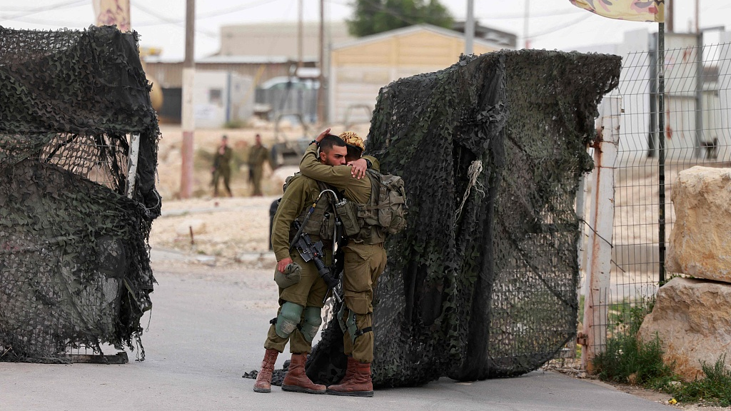 Israeli soldiers console one another outside the Mount Harif military base near the city of Mitzpe Ramon in Israel's southern Negev desert, adjacent to the border with Egypt, on June 3, 2023. /CFP