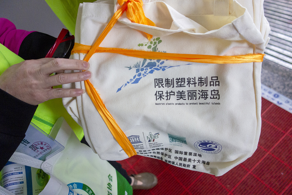 Volunteers offer tourists biodegradable bags in exchange for their plastic bags in Wenzhou, Zhejiang Province, May 7, 2023, as part of the efforts to promote the protection of local islands. /CFP