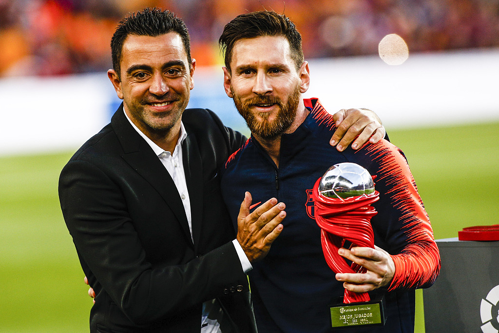 Lionel Messi (R) of Barcelona and his former teammate Xavi Hernandez pose for a photo during the La Liga game against Real Sociedad at Camp Nou Stadium in Barcelona, Spain, May 20, 2018. /CFP