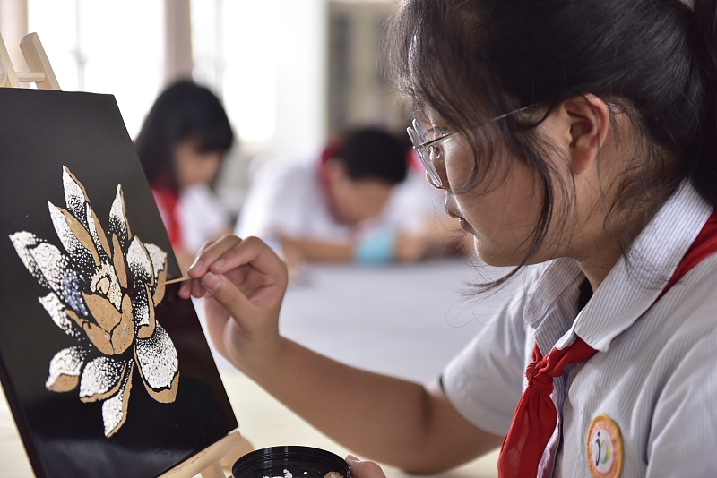 A pupil works on her eggshell painting in a classroom in Hefei, Anhui Province on June 7, 2023. /CFP