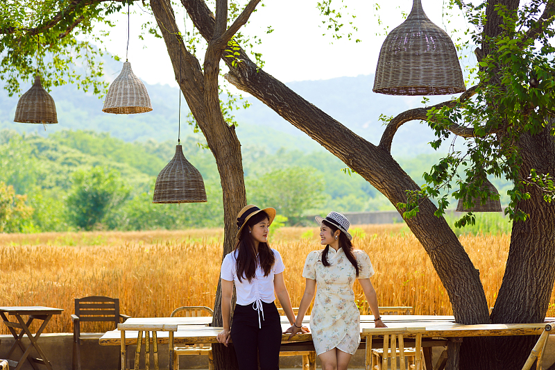 Two girls visit a wheat-themed tourist spot in Rizhao, Shandong Province on June 6, 2023. /CFP