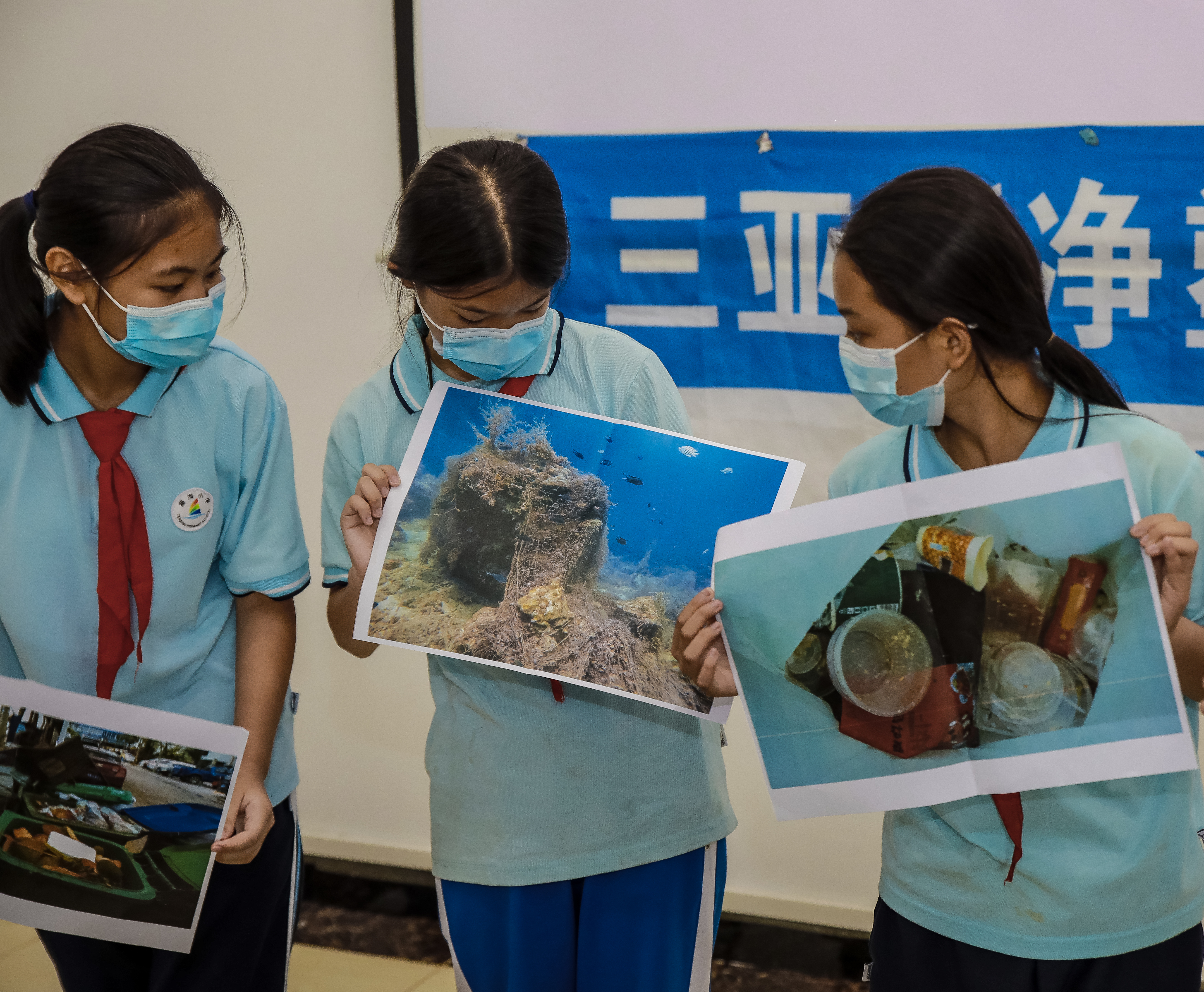 Student volunteers presenting pictures depicting plastic pollution in the ocean. /Blue Ribbon