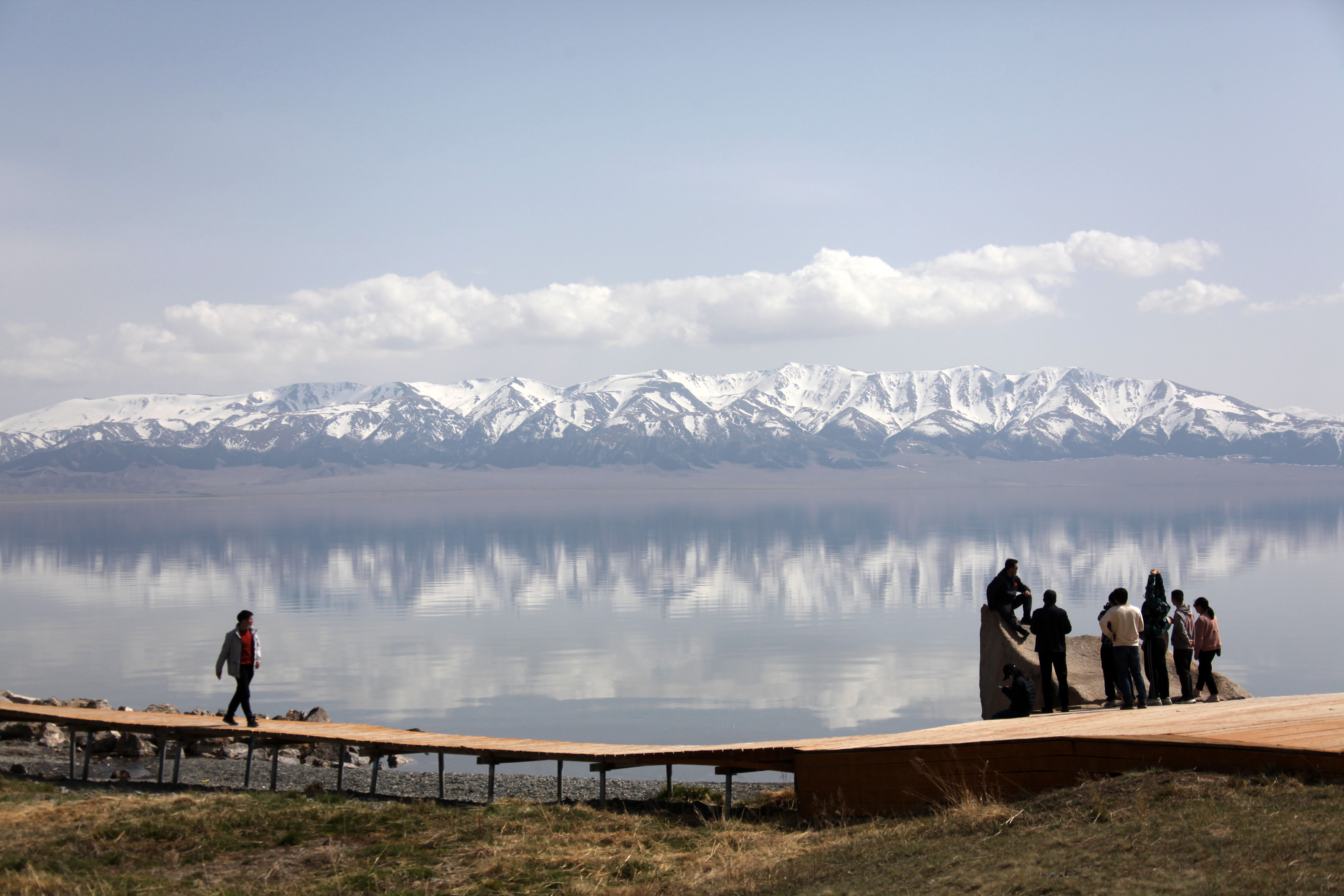 Visitors enjoy the scenery from the shore of Sayram Lake located in the northern Tianshan Mountains in Bortala Mongol Autonomous Prefecture in Xinjiang. /CNSPHOTO