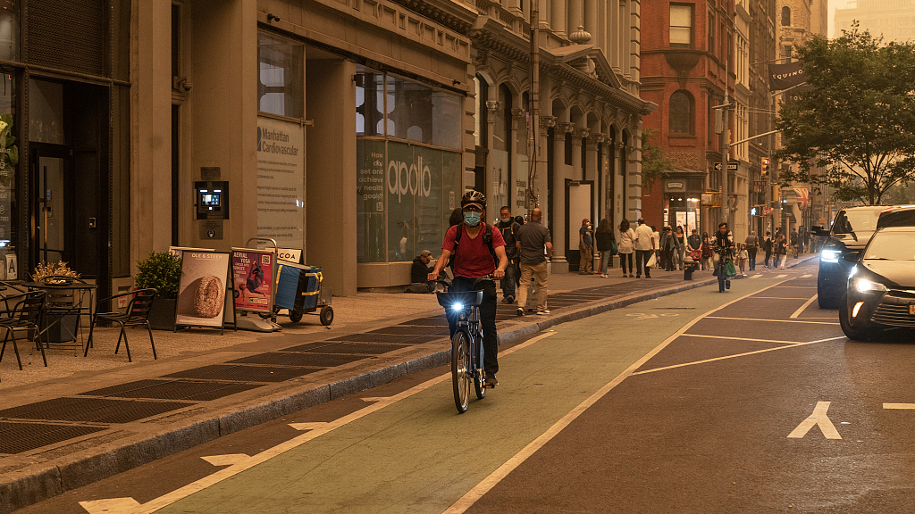 A man wears a mask while riding a bicycle in New York City, U.S., June 7, 2023. /CFP