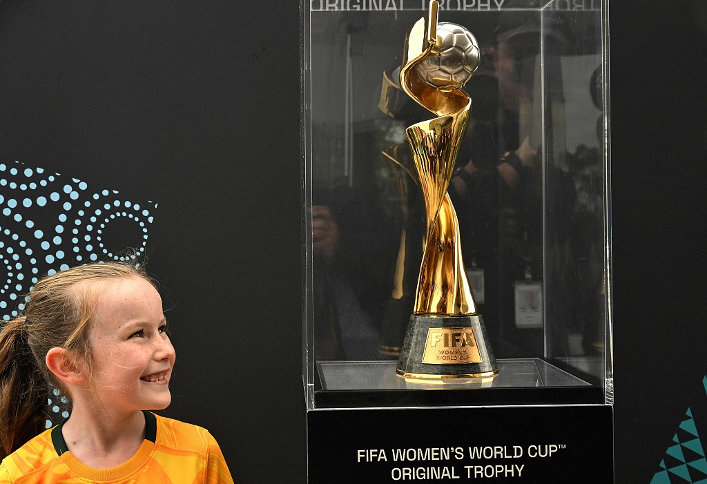 A girl smiles as she looks at the trophy for the FIFA Women's World Cup during a trophy tour at Taronga Zoo in Sydney, Australia, June 8, 2023. /CFP 