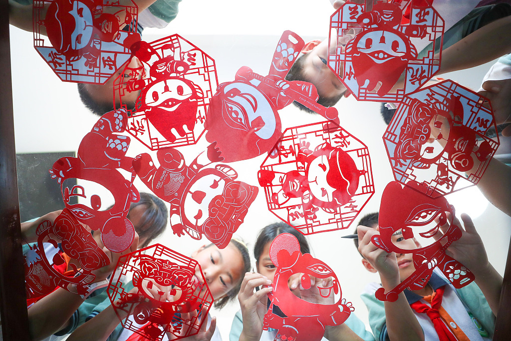 Students from a primary school in Huzhou, Zhejiang show their papercutting works themed on the mascots of the 19th Asian Games on June 9, 2023. /CFP