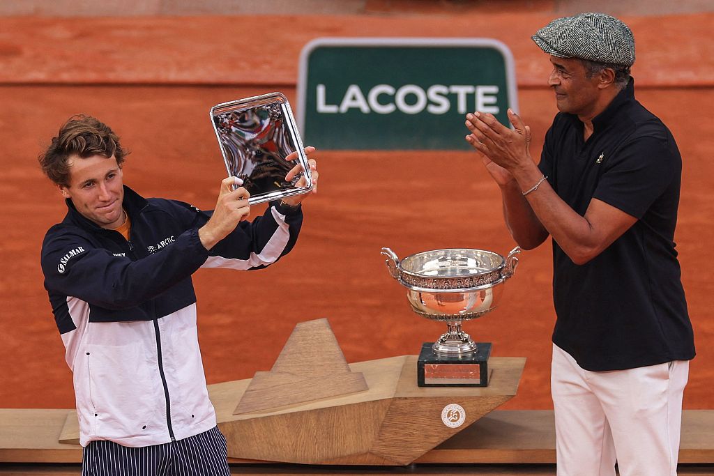 Casper Ruud (L) poses with his trophy alongside former French tennis player Yannick Noah at the Court Philippe-Chatrier in Paris, France, June 11, 2023. /CFP