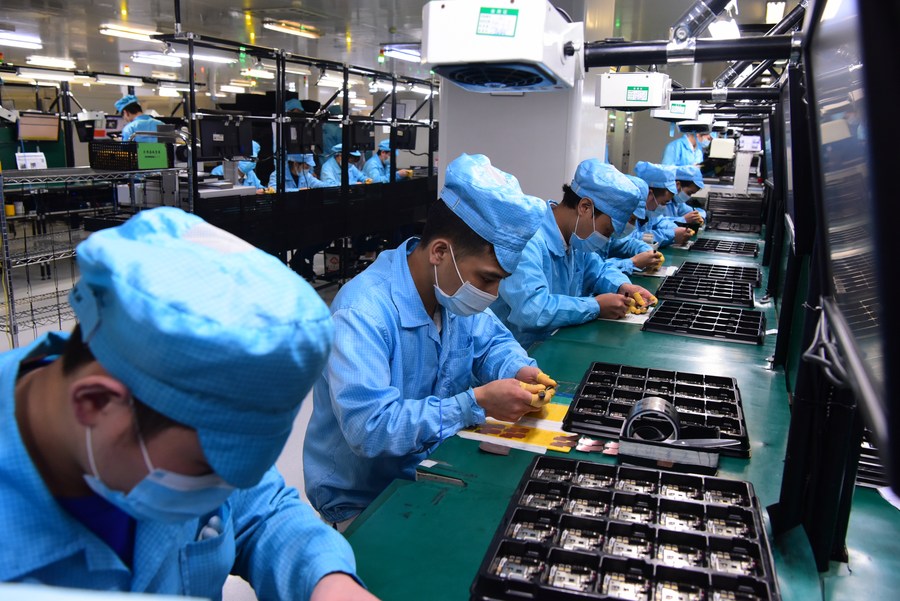Staff wearing masks work at the factory of OPPO in Dongguan City, south China's Guangdong Province, February 13, 2020. /CFP