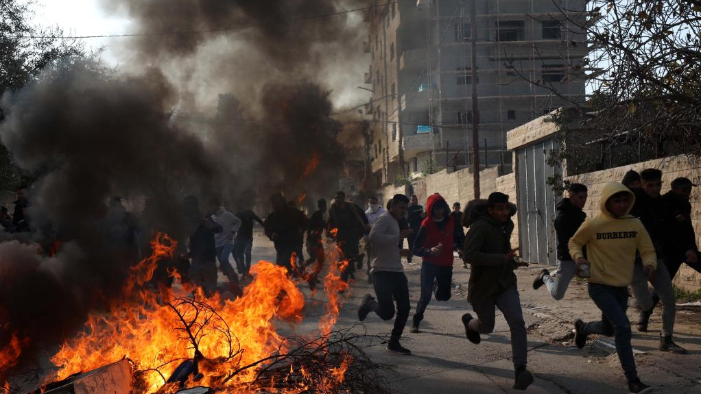People run to take cover during clashes with Israeli forces in the West Bank city of Jenin, January 26, 2023. /Xinhua