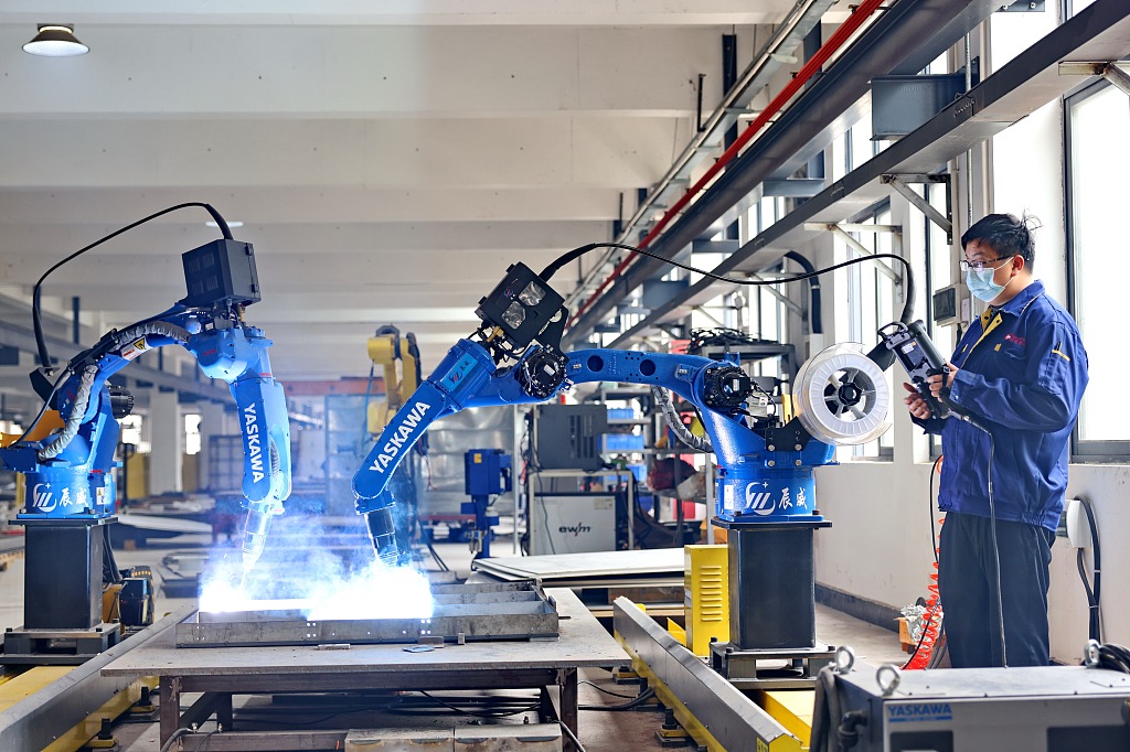 A worker operating robotic arms in a workshop in Ganzhou, Jiangxi Province, May 10, 2023. /CFP