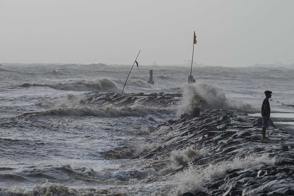 A boy walks as high tide waves hit the Arabian Sea coast at Juhu Koliwada in Mumbai, India, June 12, 2023. /CFP