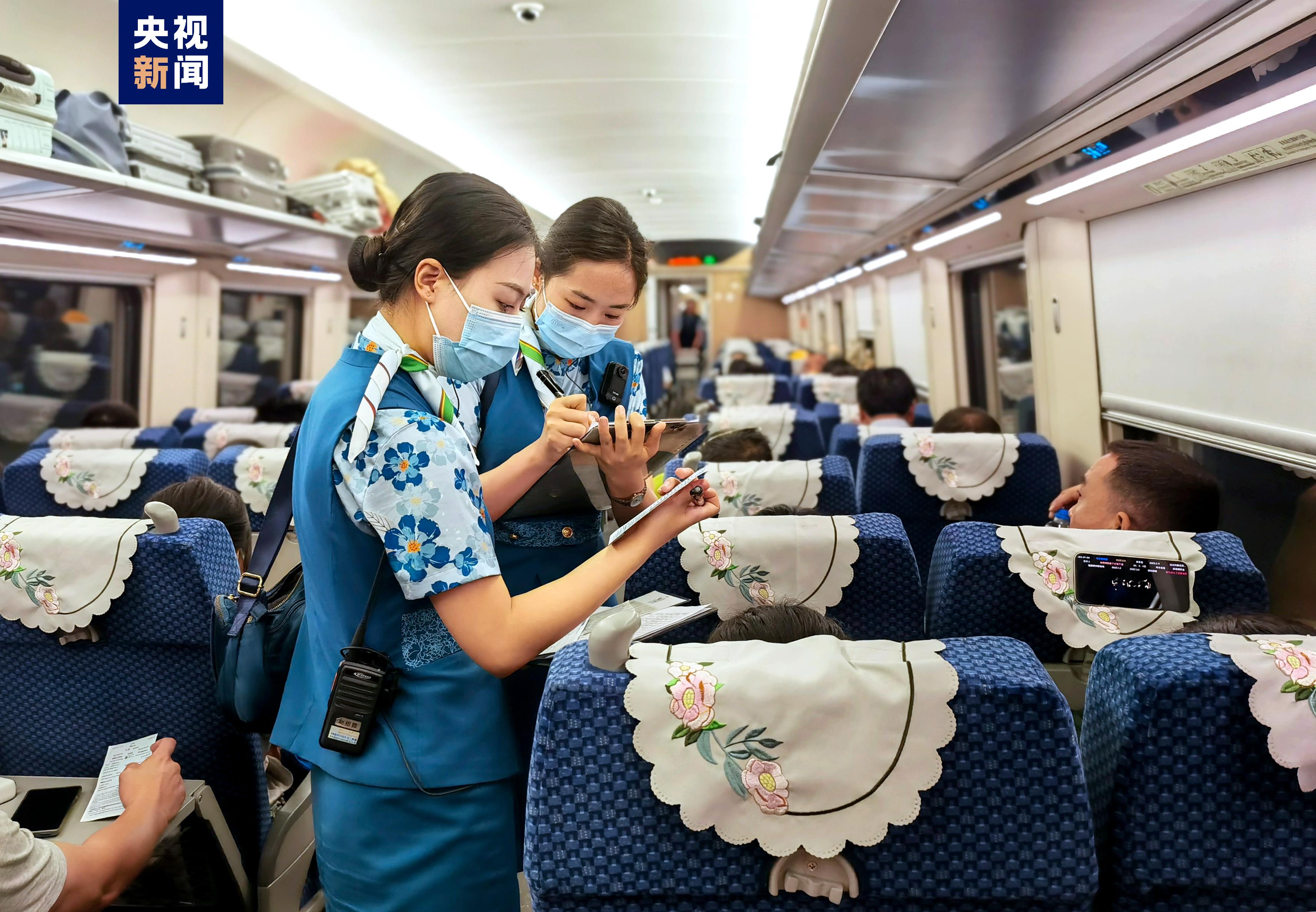 Staff members serve passengers on train. /China Media Group
