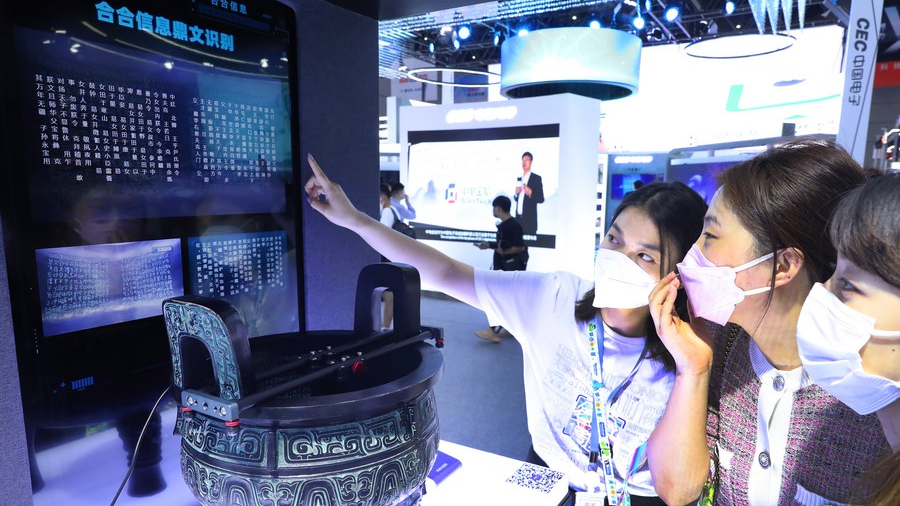 A staff member (1st L) introduces an AI character recognition system to visitors at the 2022 World Artificial Intelligence Conference (WAIC) in east China's Shanghai, September 1, 2022. /Xinhua